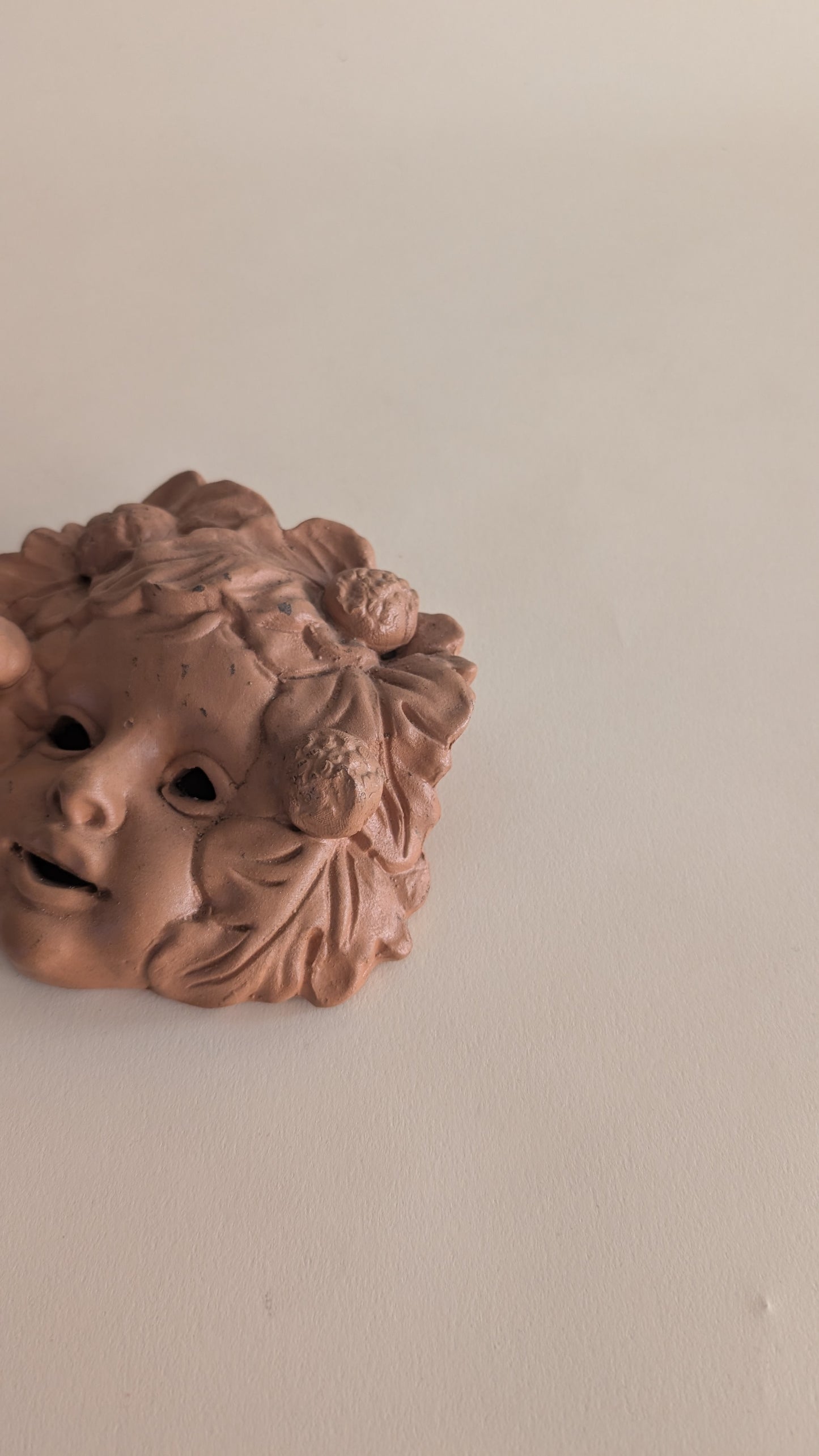 Masque mural vintage en terre cuite – visage d’enfant fleuri