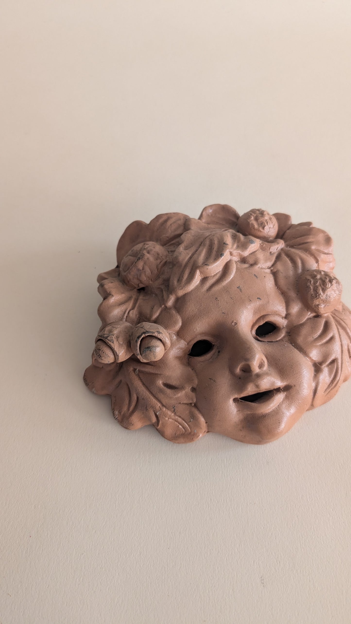 Masque mural vintage en terre cuite – visage d’enfant fleuri